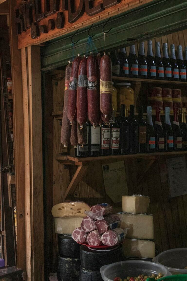 Selection of hanging salamis and cheeses in a market stall, Puerto Iguazú, Argentina.